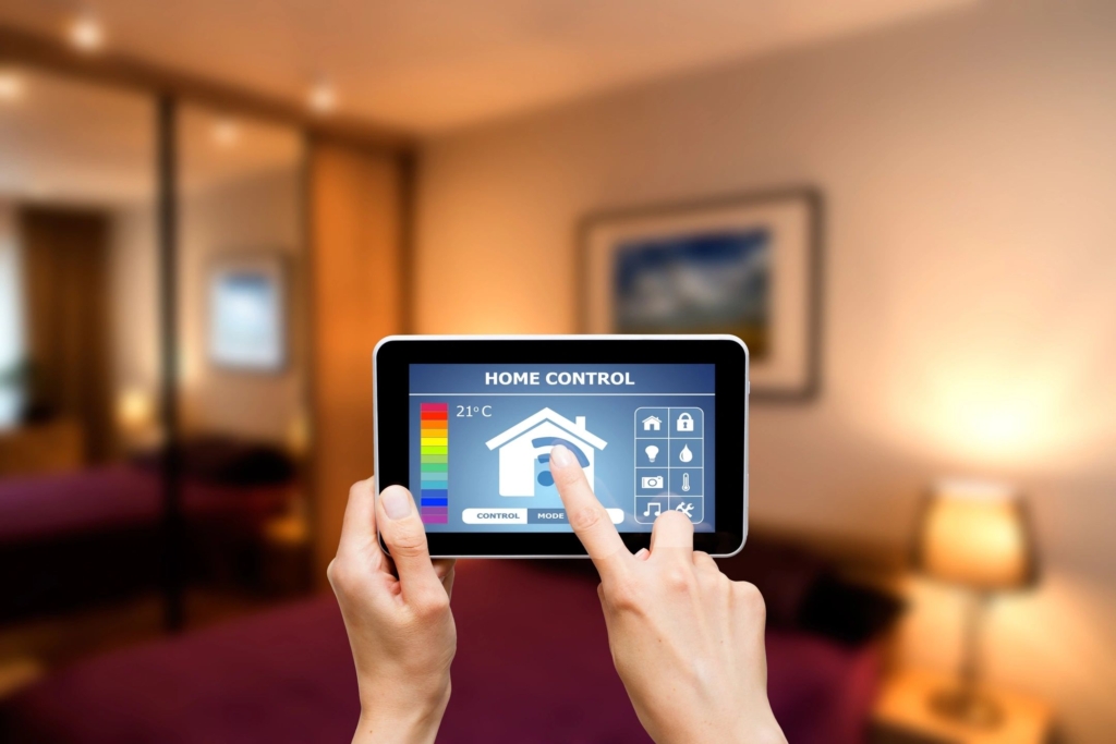 A person holding a tablet with home controls on it